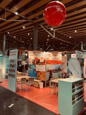 Conception et fabrication de stands d'exposition pour foires et salons. solution Le Transversale avec location mobilier et pont lumière - impressions de tissus - Ballon Hélium drapeaux - banques menuisées